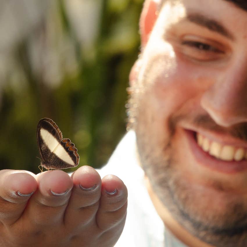 man with a gentle urge to protect holding a butterfly