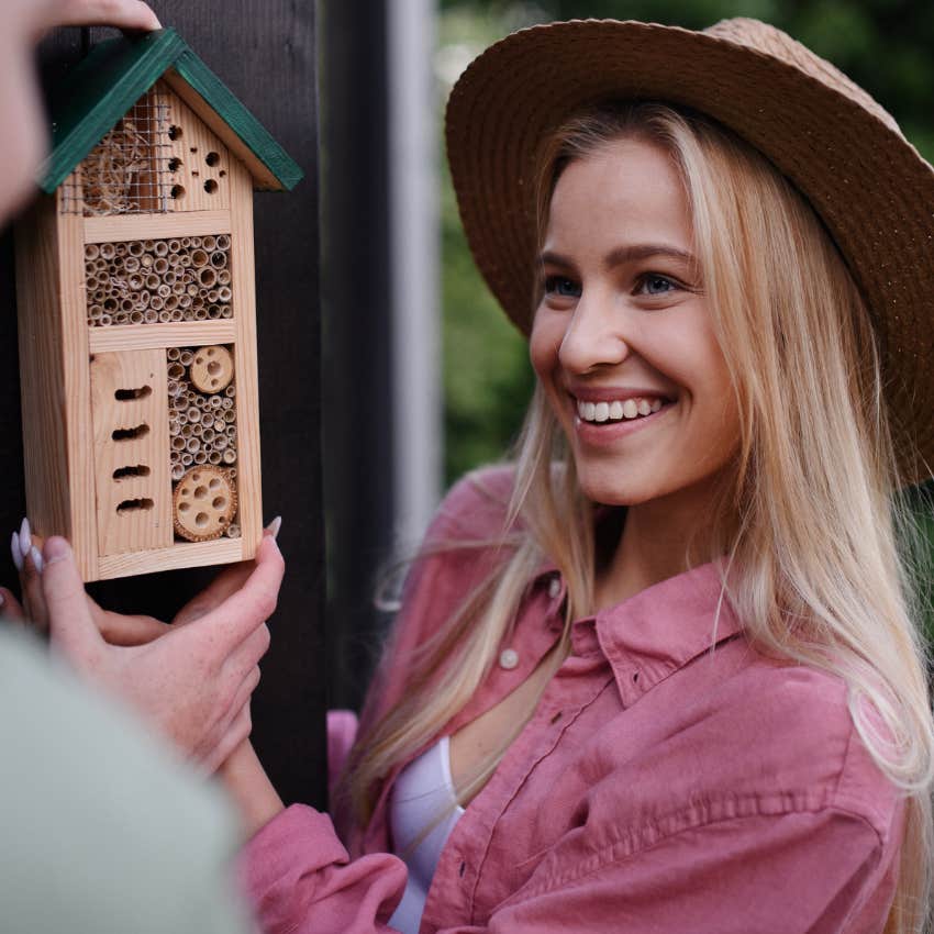 woman with empathy for the things others overlook holding bee house outside