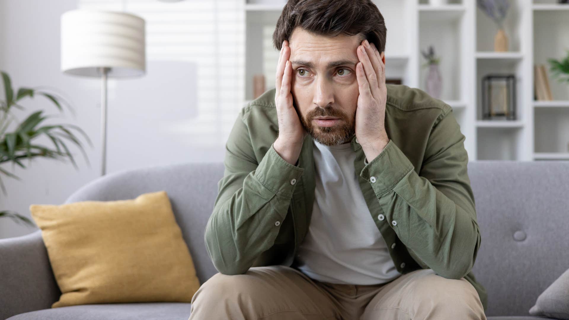 frustrated man self-sabotaging sitting at home alone