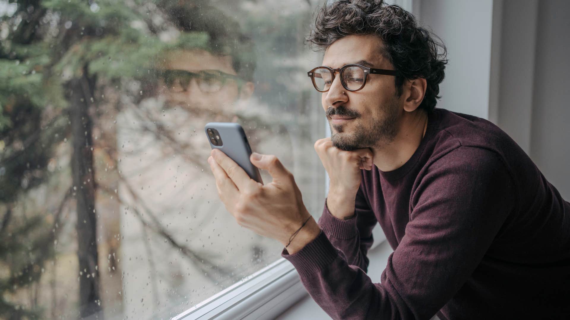 introverted man happy about canceled plans on his phone