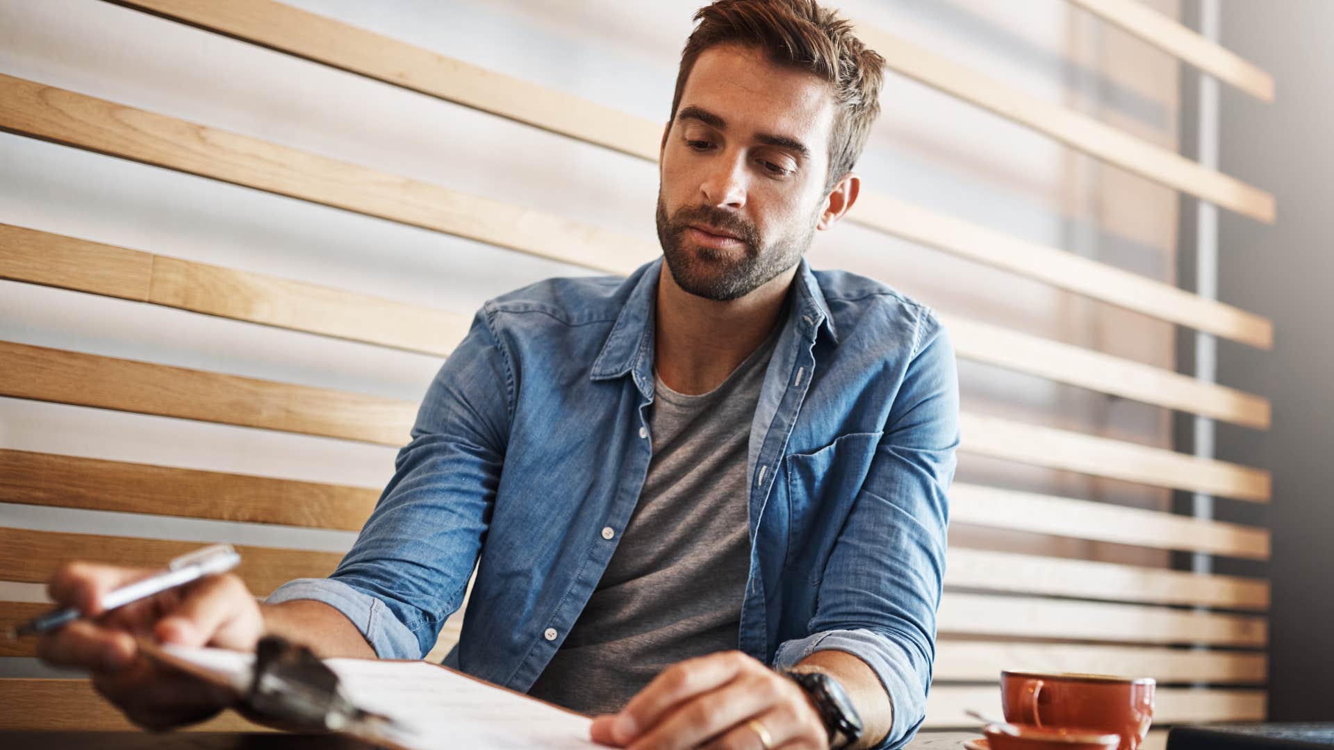 man sitting in empty coffee shop working