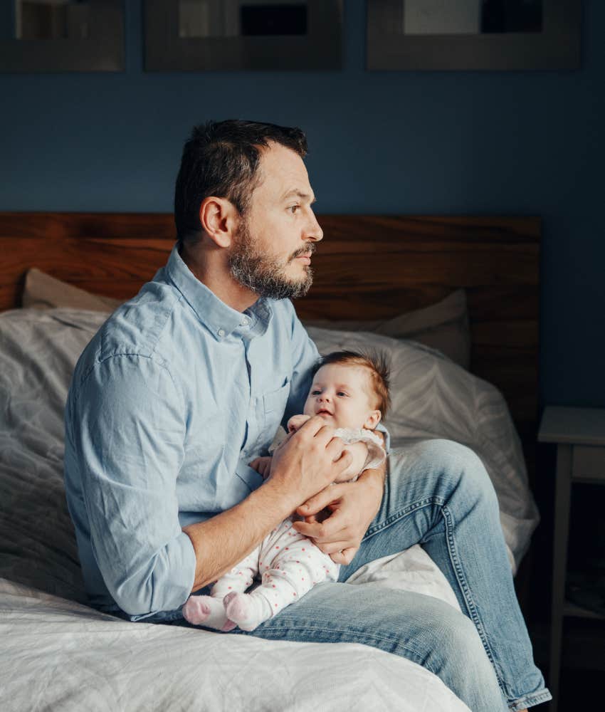 introspective father holds baby showing imagination of future