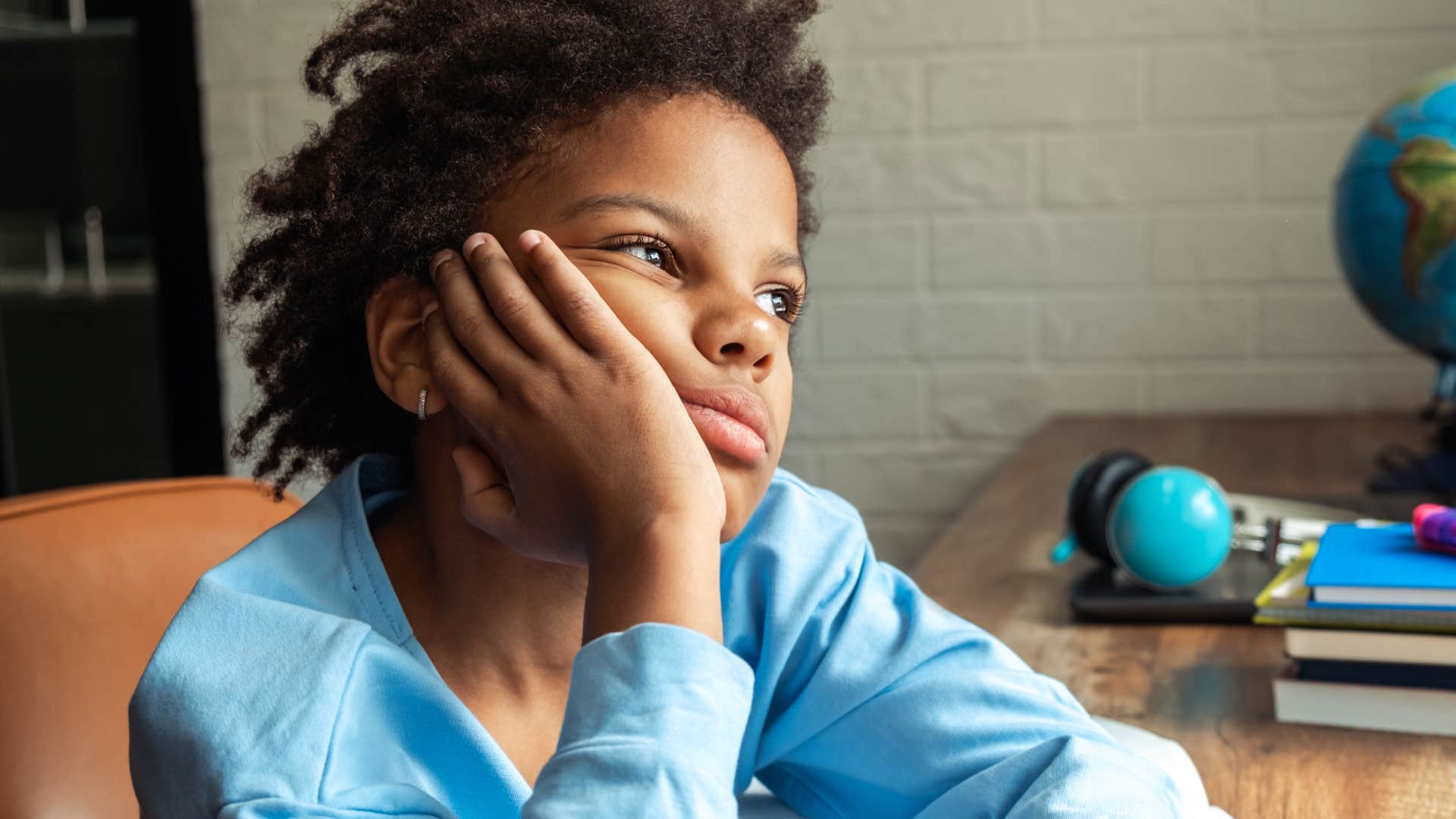little boy raised by boomer parents sitting with discomfort and boredom at home