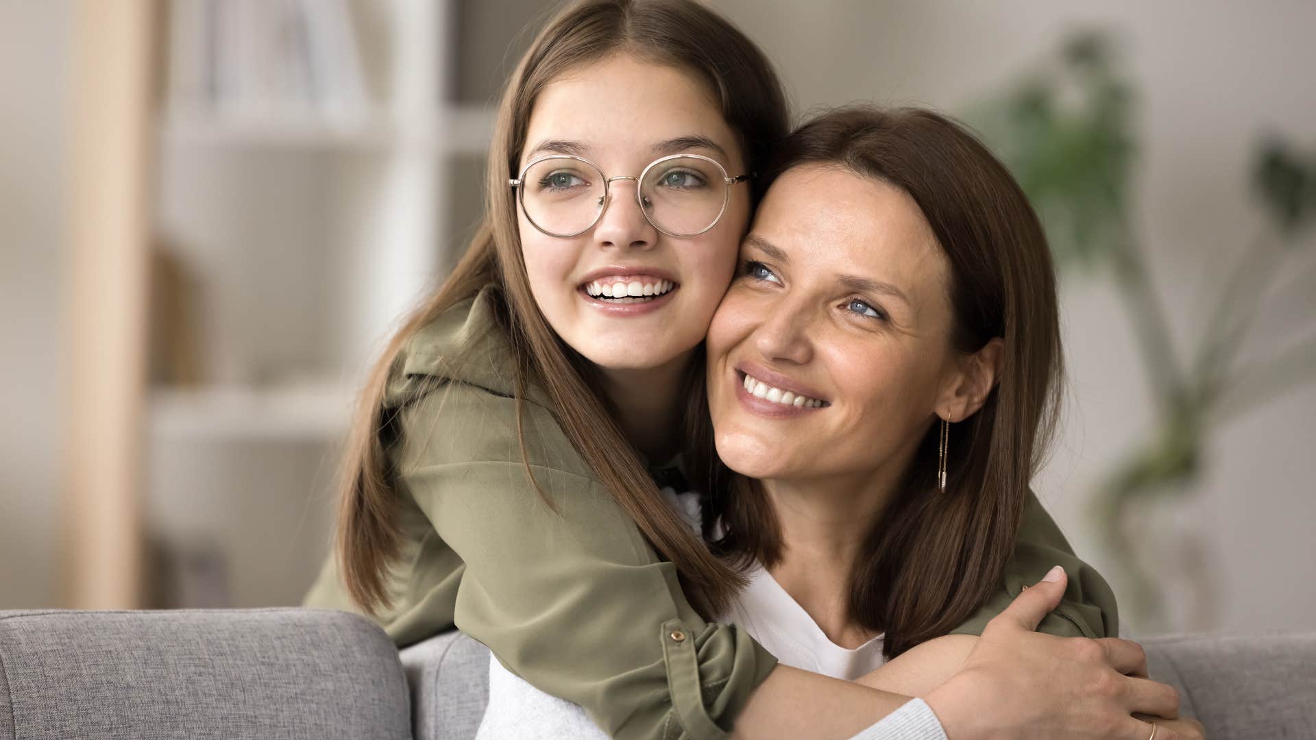 teen daughter being deeply sentimental hugging mom