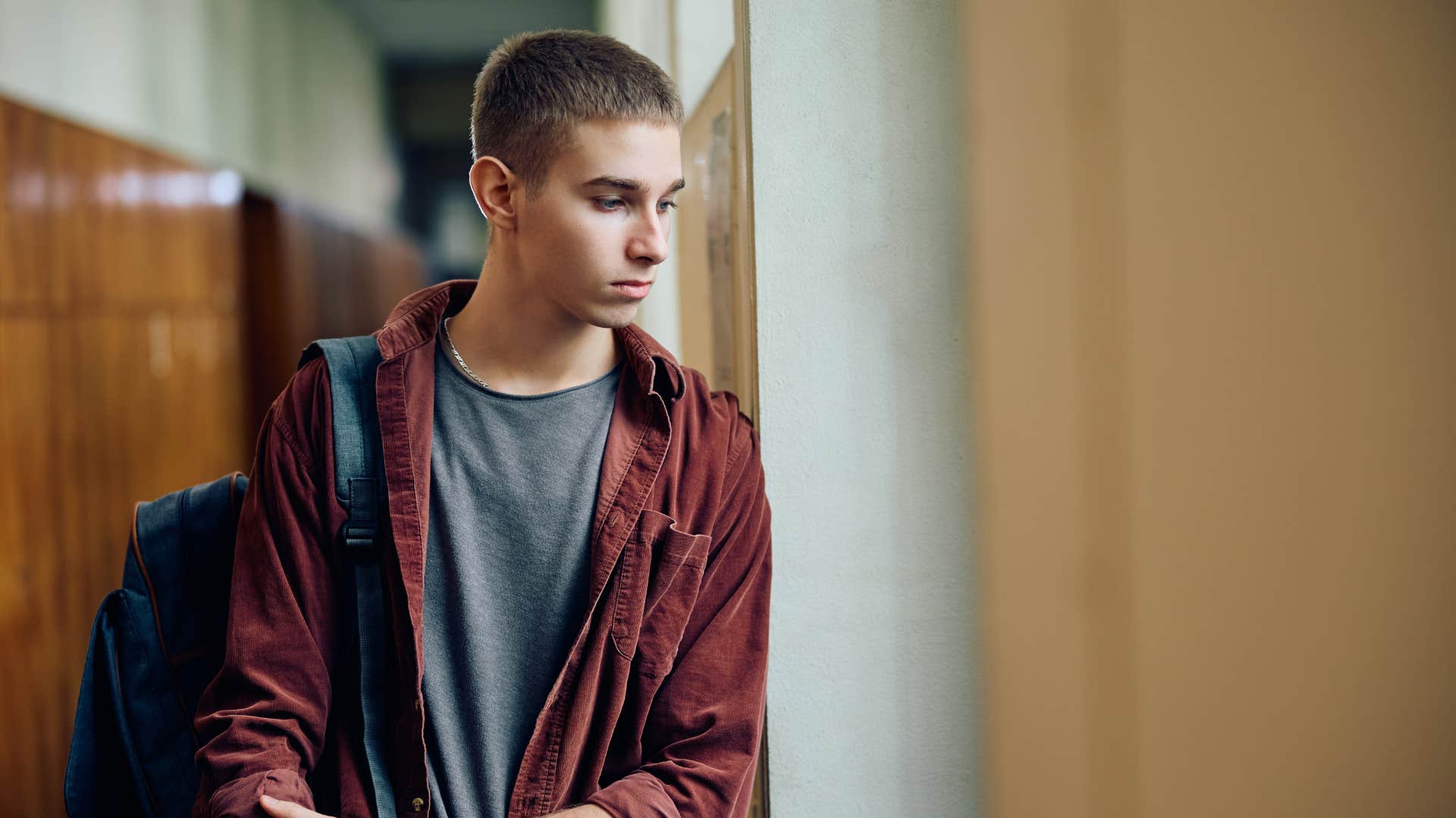 teenage boy standing alone feeling protective