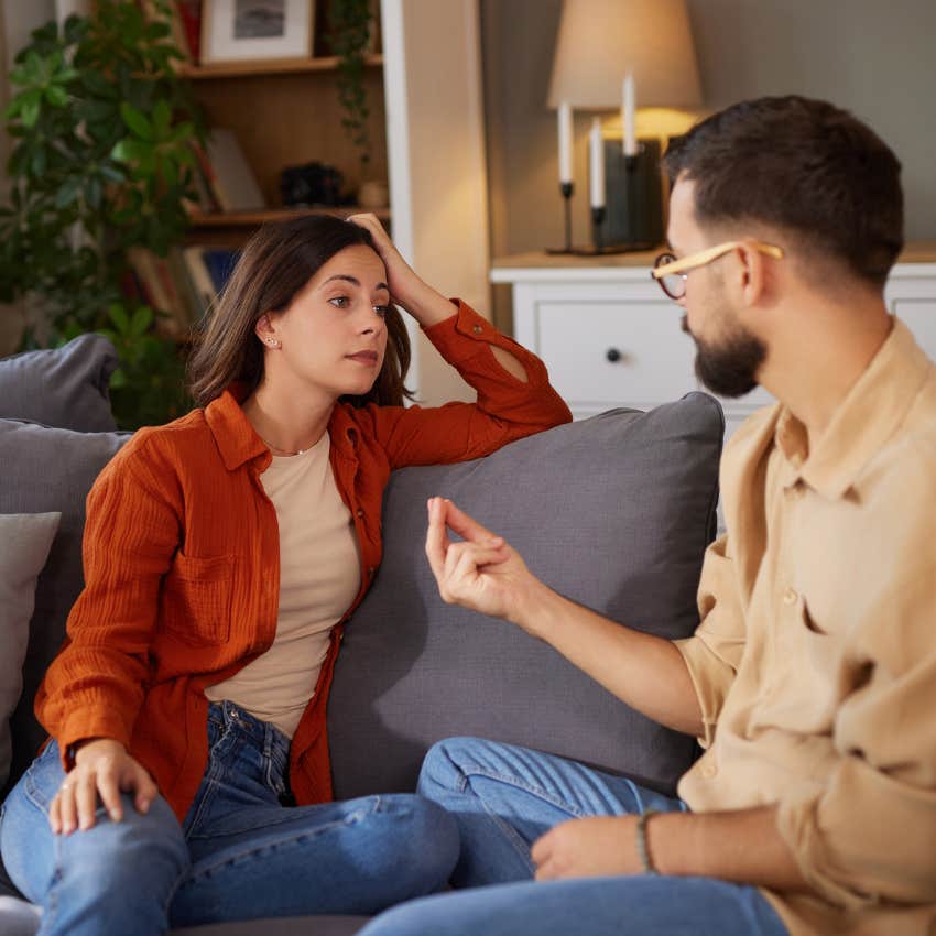 couple having serious conversation sitting on couch