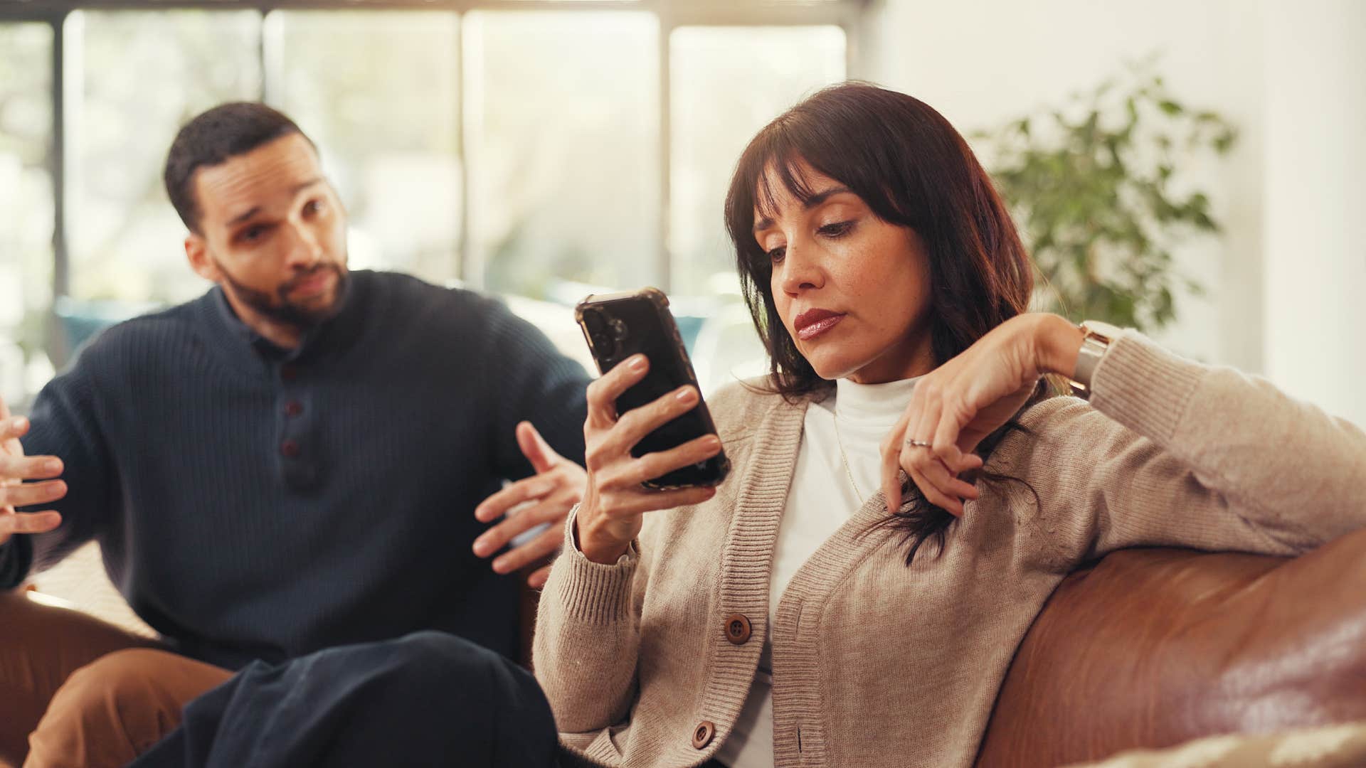 woman being overly guarded about her phone ignoring her husband