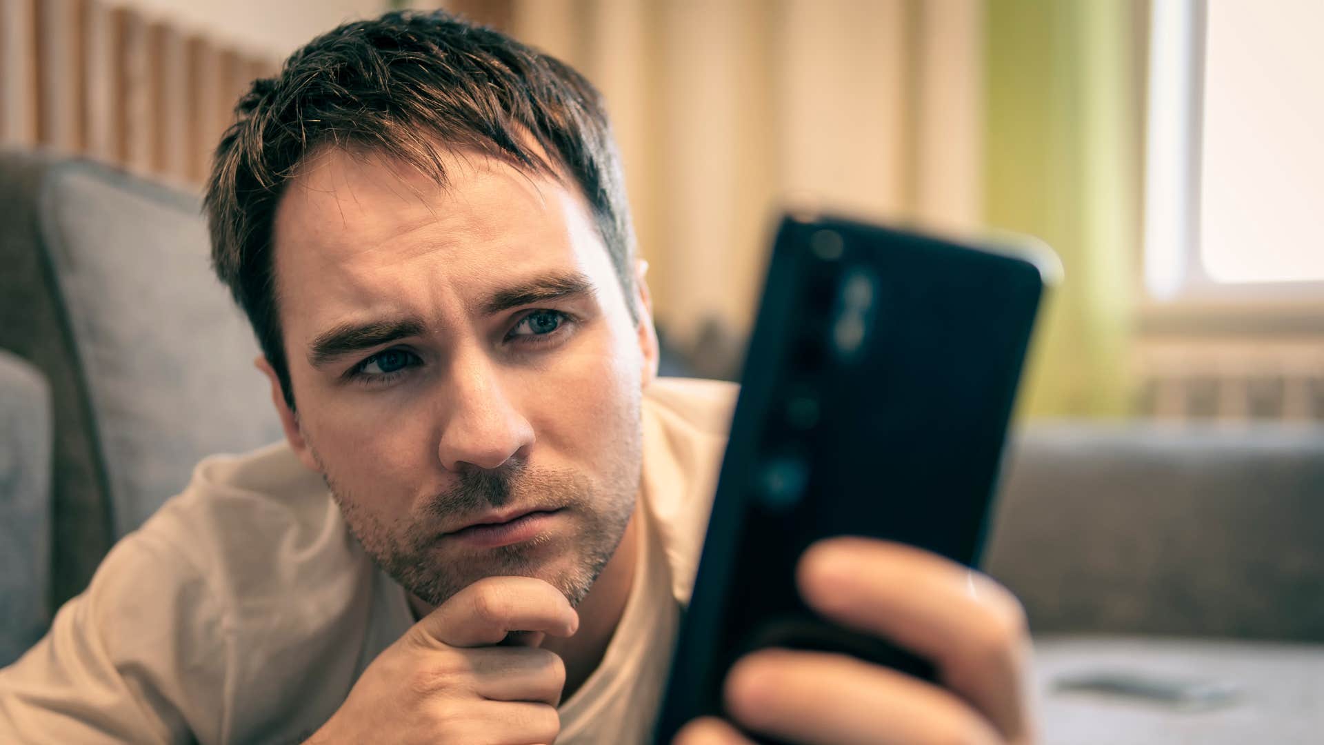 man looking at his phone curating his social media