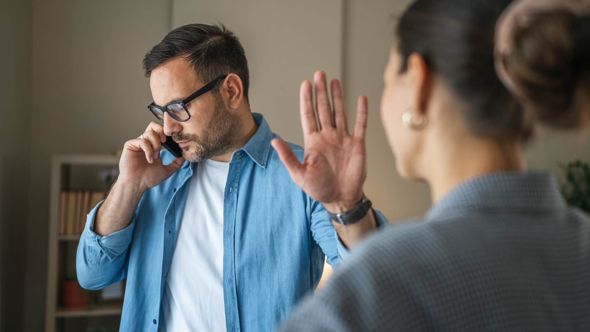 man who is cheating talking on phone too busy for his wife