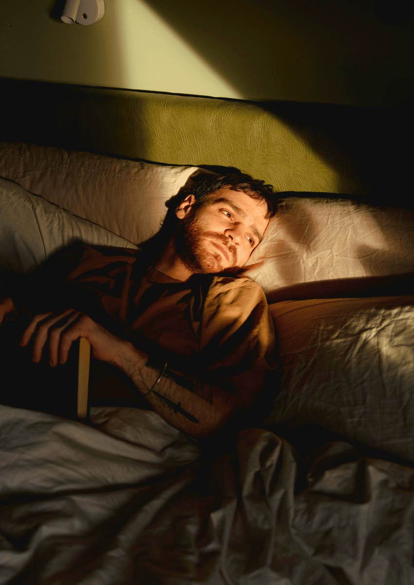 man lying awake in bed at night