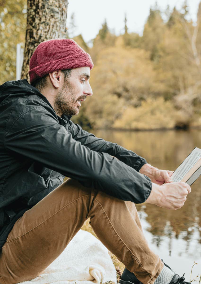 man reading a book in nature