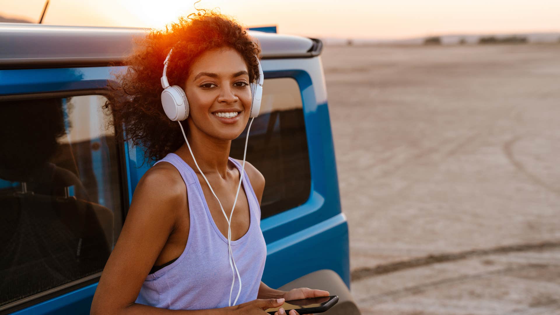 Joyful woman in the desert by a jeep manifesting abundance 