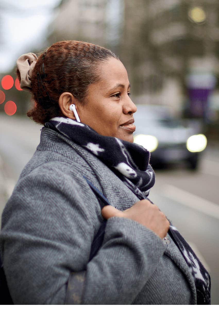 mature woman wearing earbuds while walking