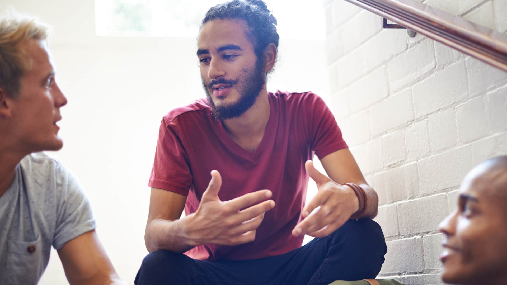 man trying to get attention talking in a lower voice with his guy friends