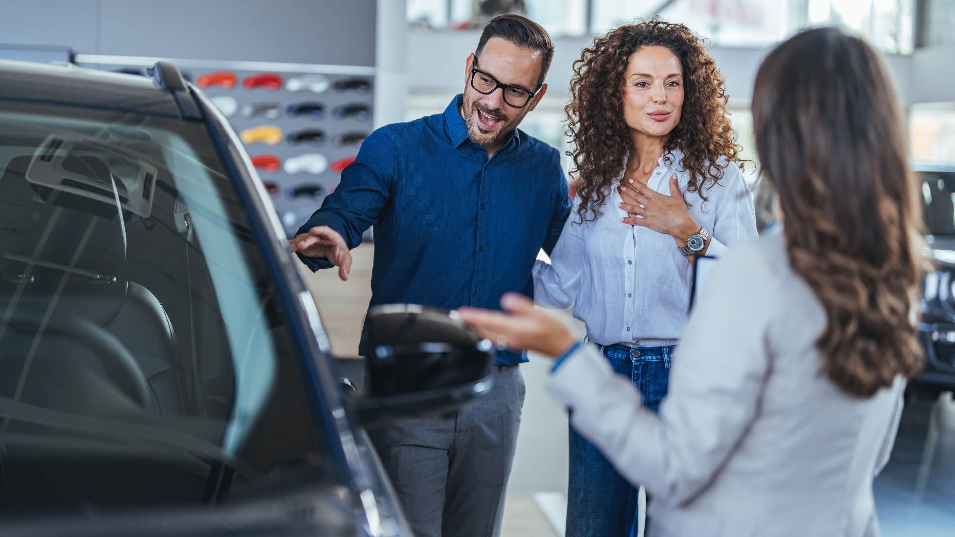 couple buying expensive cars as they check out black car