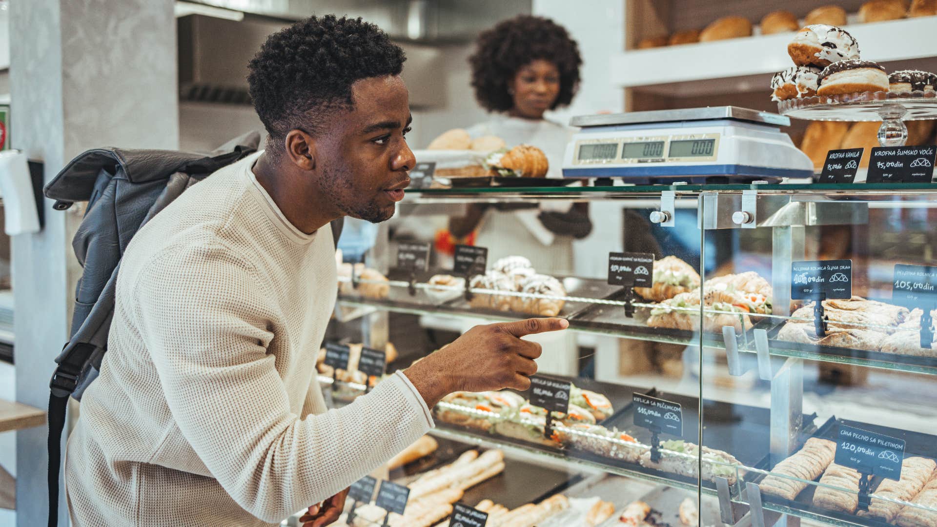 man in white shirt shopping as he's spending money on too many small treats