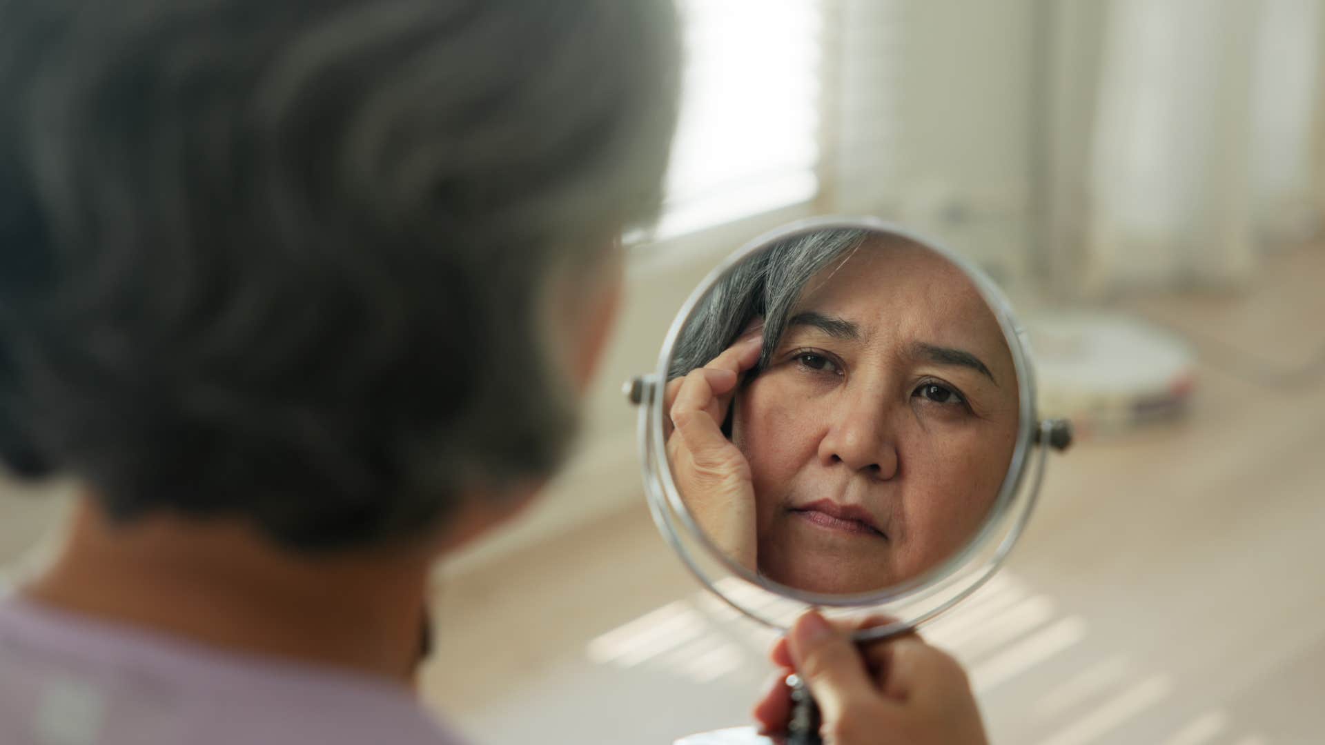 older person sees how tired they are in mirror