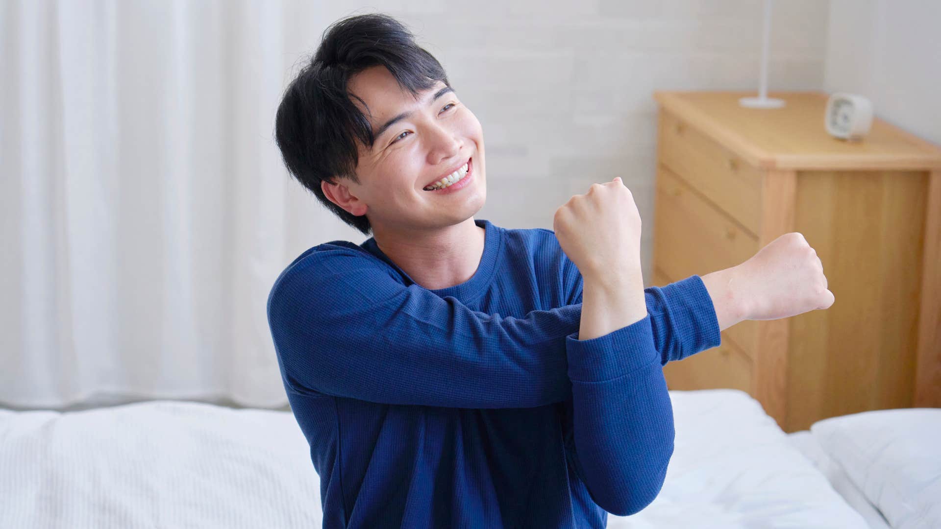 man in dark blue shirt being pain free as he stretches