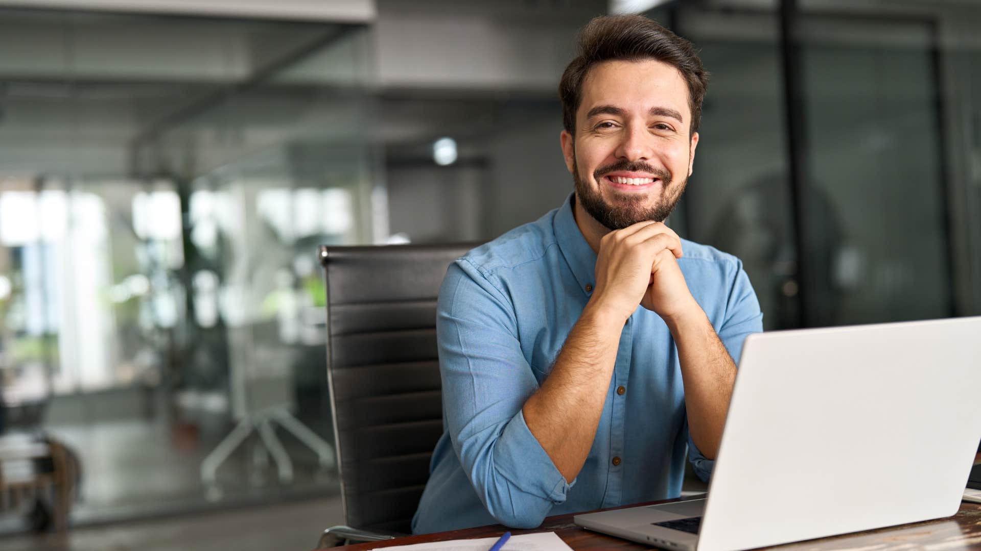 man in blue shirt working as he has financial stability