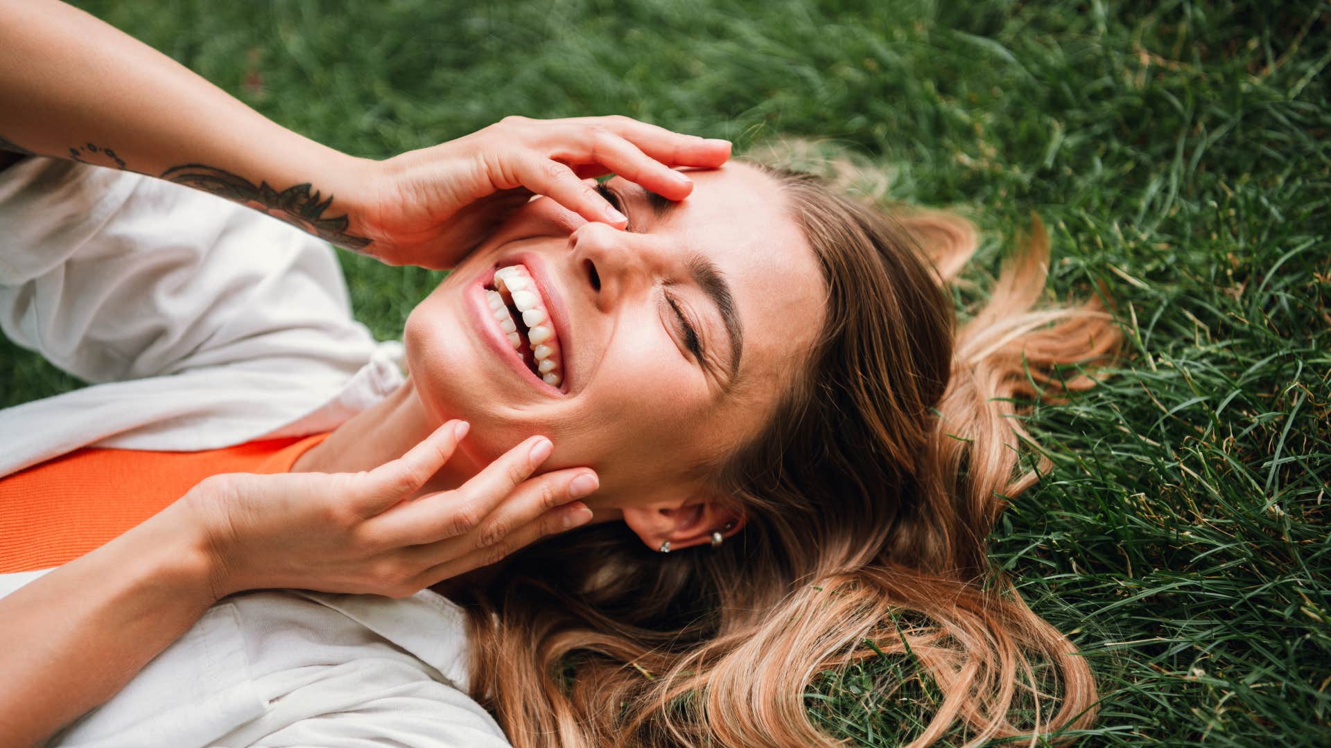 woman smiling brightly on grass as she has her freedom and independence