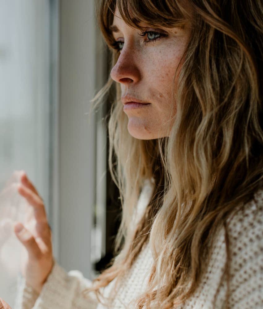 introspective woman stares out window showing not scared of death