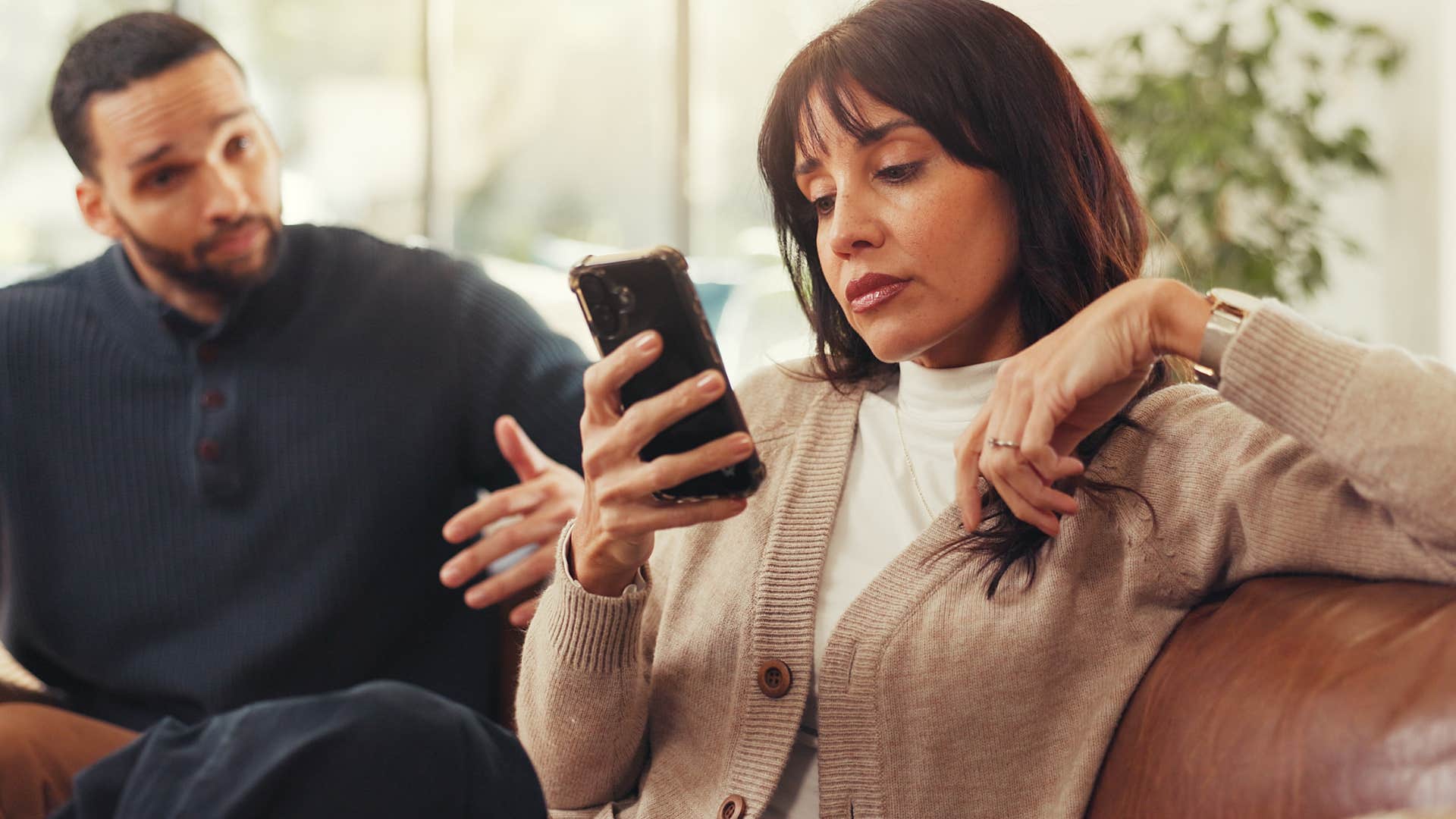 woman on her phone instead of listening to her friend speak