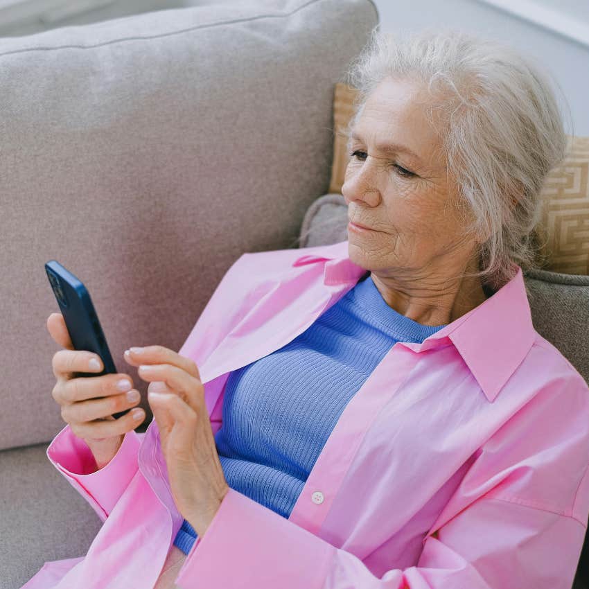 distracted elderly woman playing video game on phone