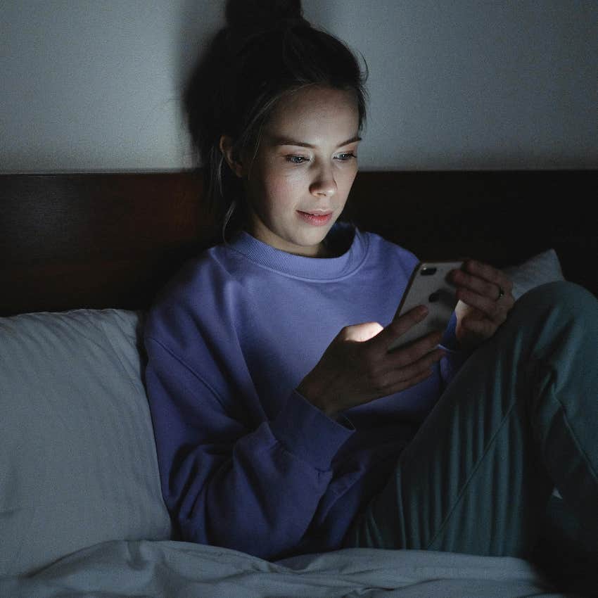 woman playing game on phone when she should be sleeping