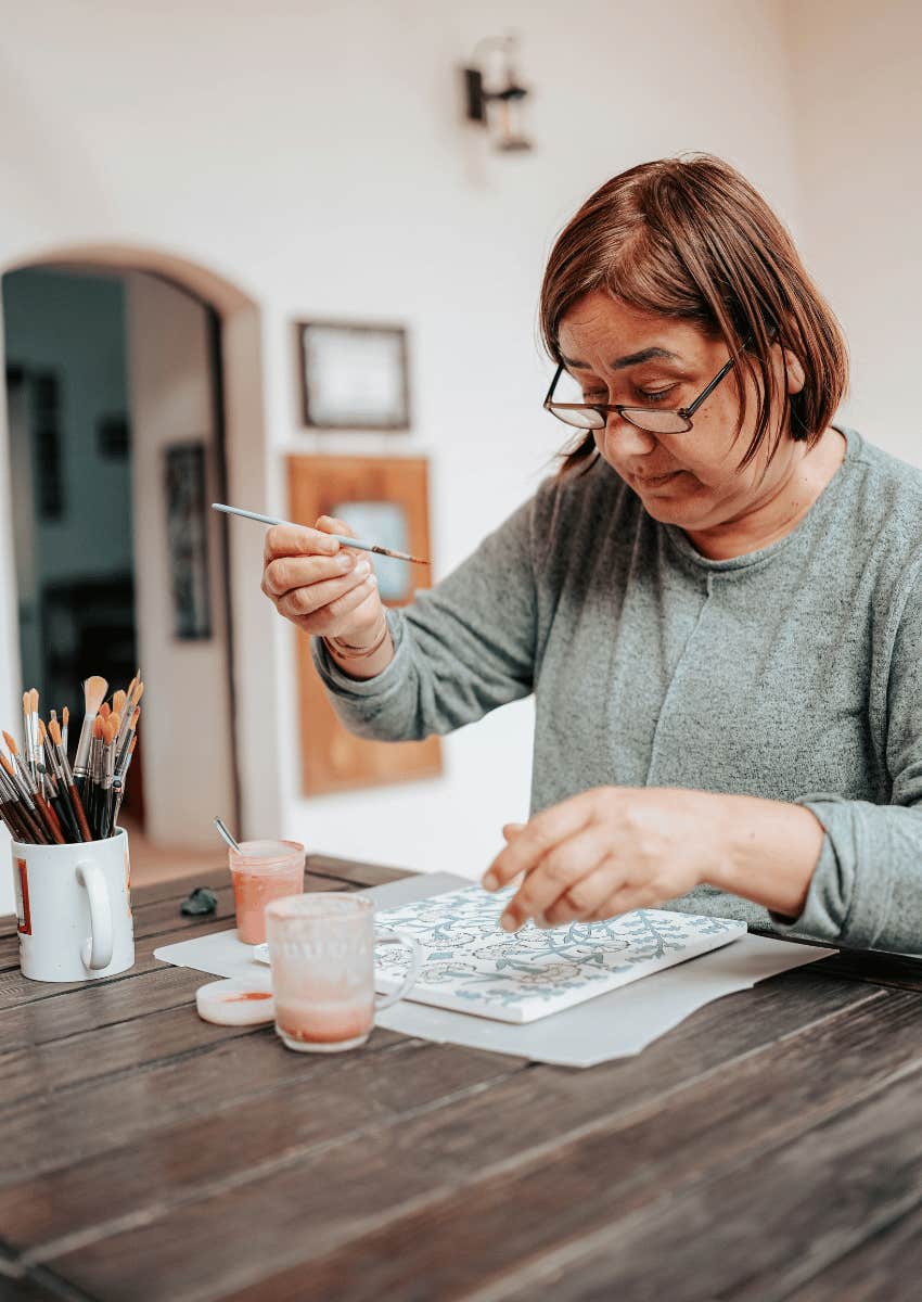 older woman learning how to paint to stop wearing down her brain