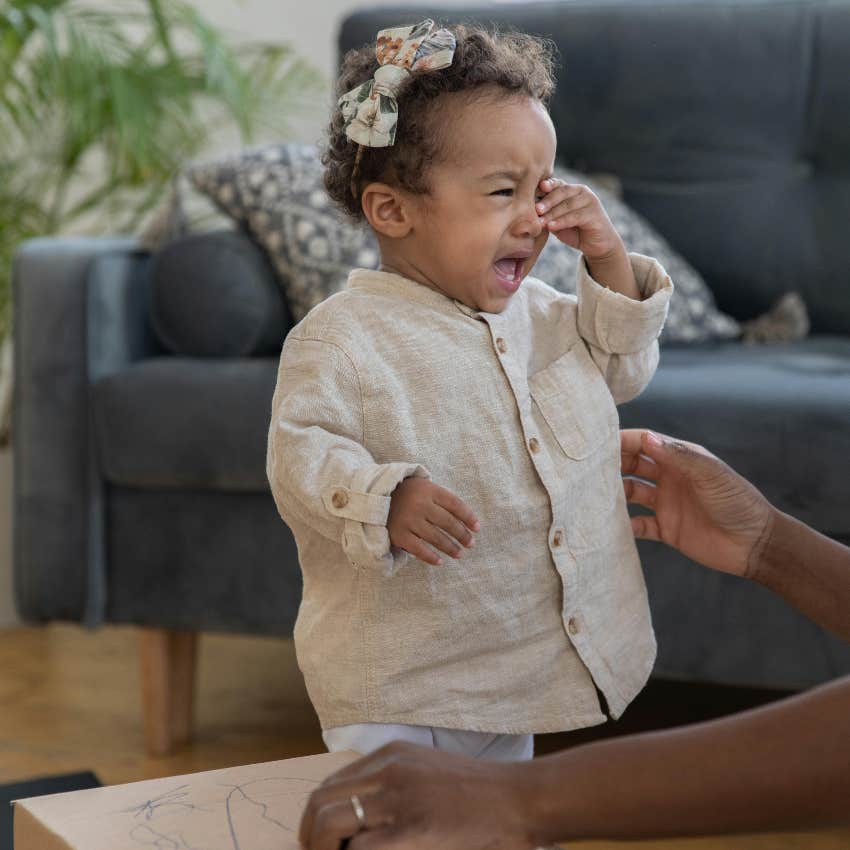 toddler walking to her dad while throwing a tantrum