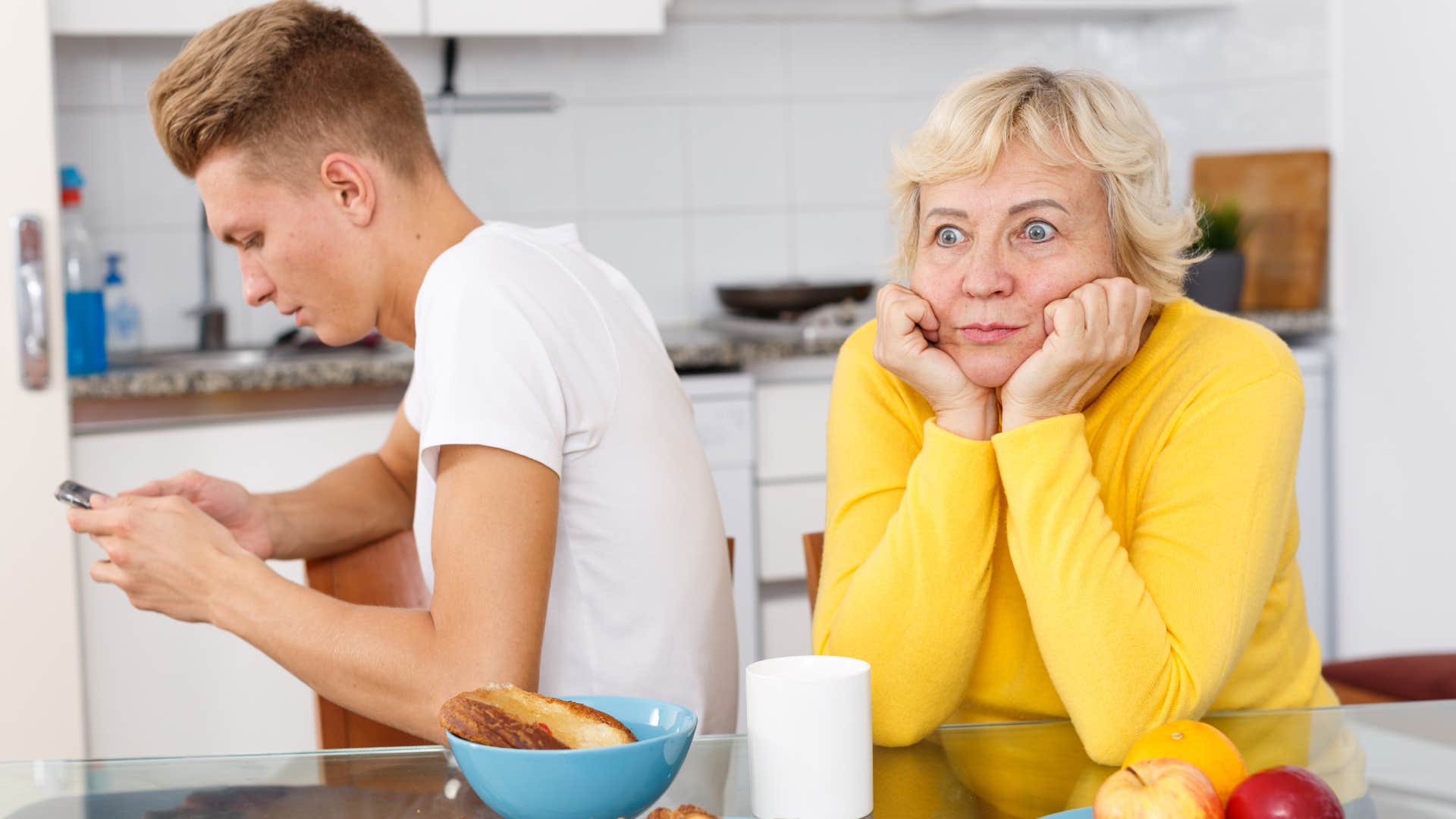 Older mother who looks like she doesn't like her grown son 