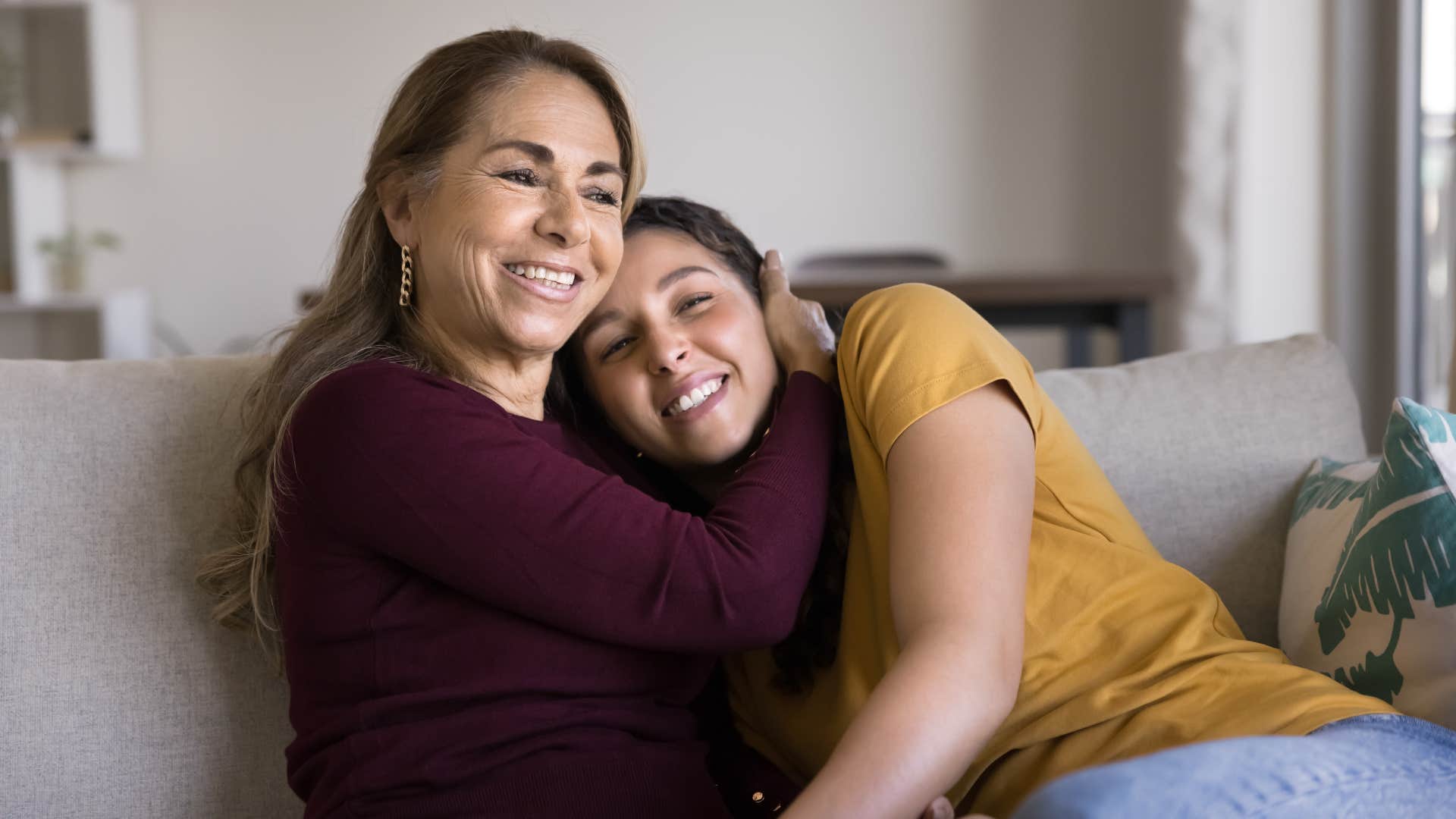 mother and daughter hugging on couch as daughter in yellow is comfort oriented