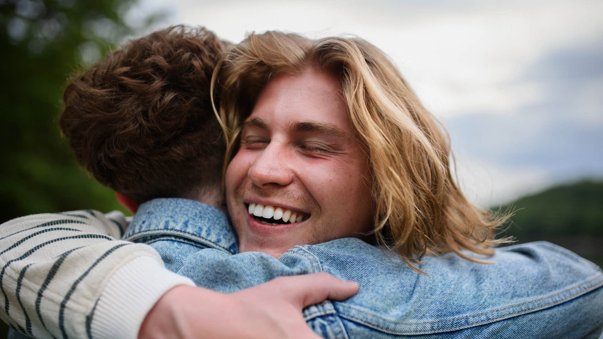 man hugging friend as they're highly loyal