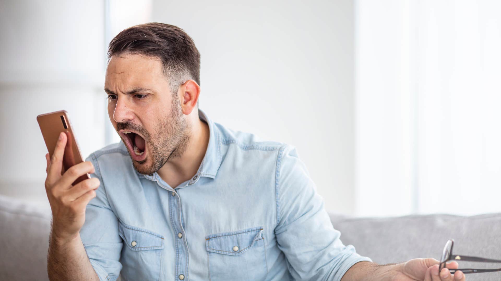 man yelling at his phone being aggressive