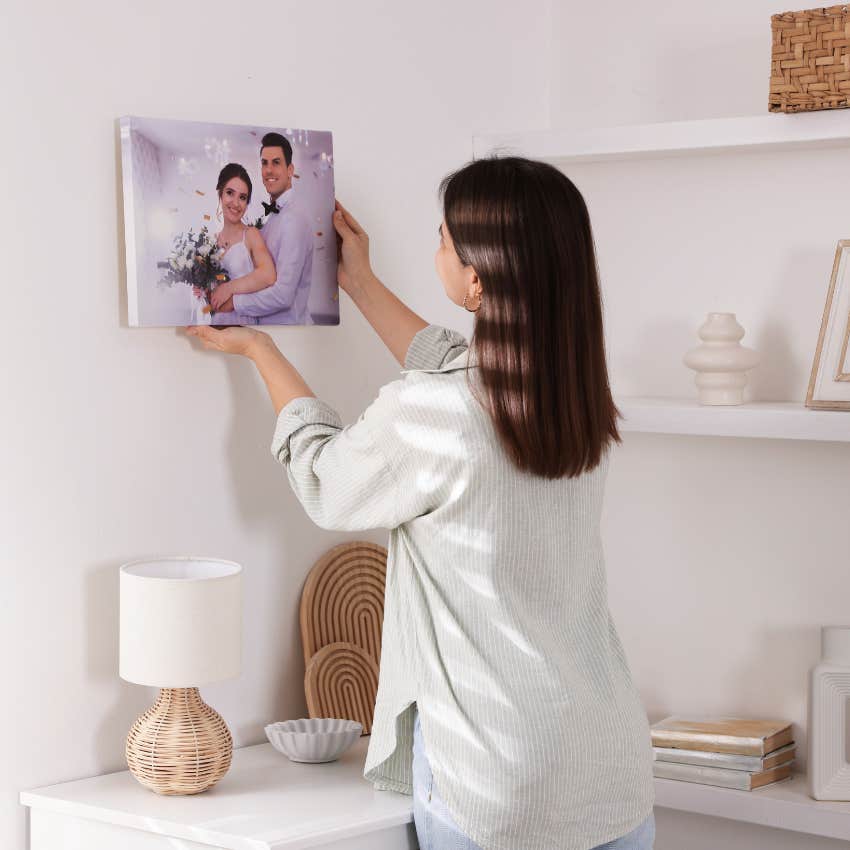 woman hanging a wedding photo prefers physical copy of image
