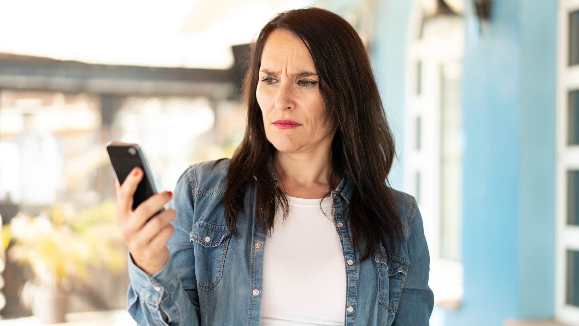 woman looking at people lying on her phone noticing deception