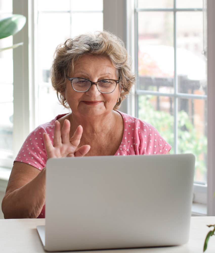 older person waves at laptop showing virtual group to build connection