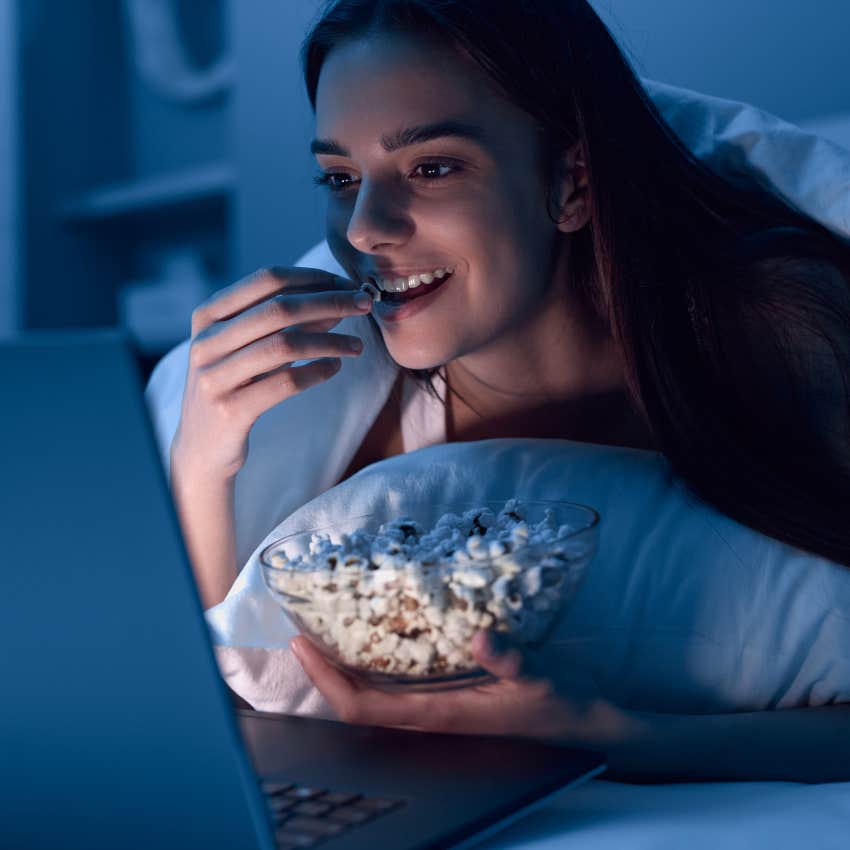 Woman who's a night owl eating popcorn after snacking all day
