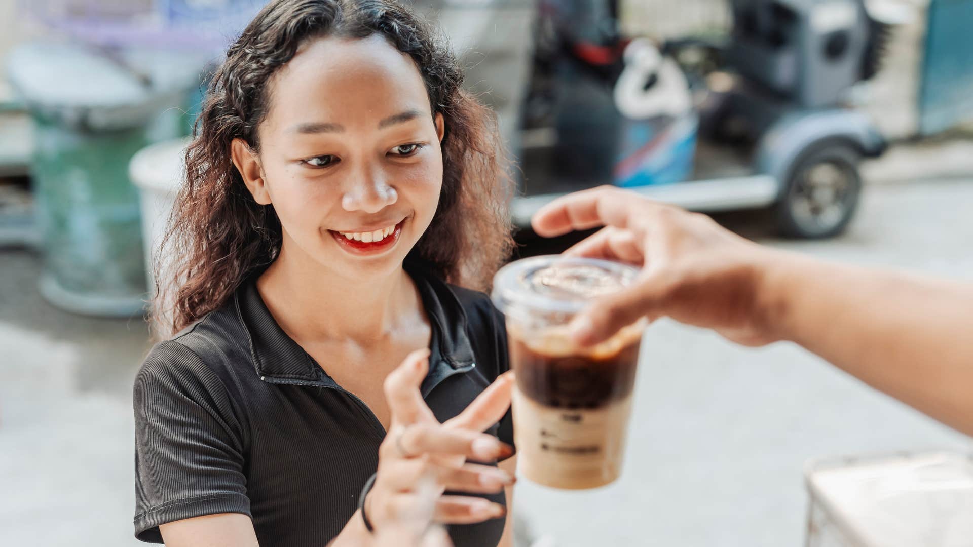 Open-minded woman smiling at her coffee.