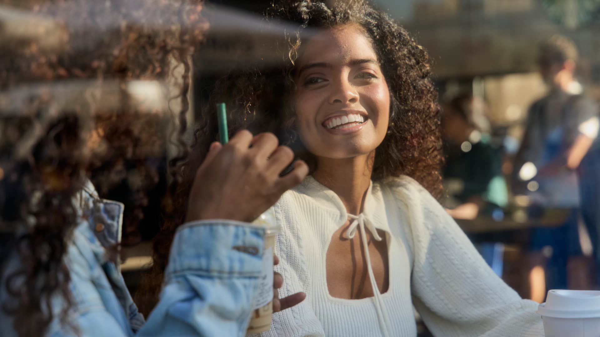 Very observant woman smiling in a coffee shop.