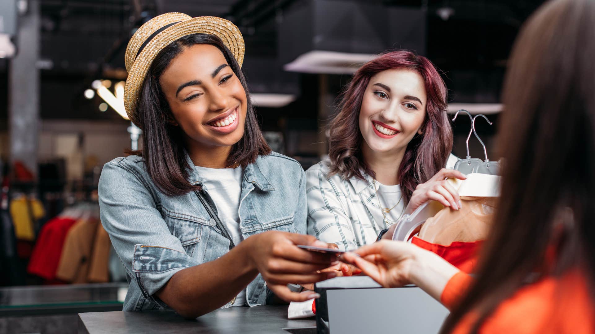 Warm-hearted person smiling and paying at a store.