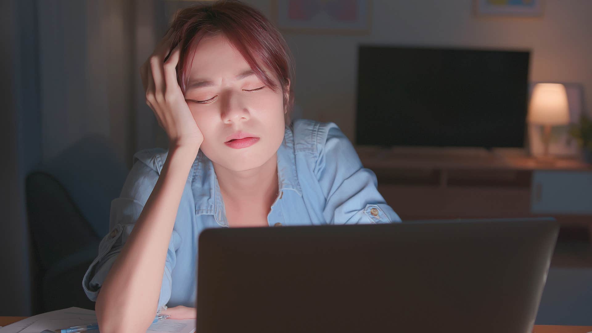 Woman who pushes off everything until tomorrow sitting in the dark.