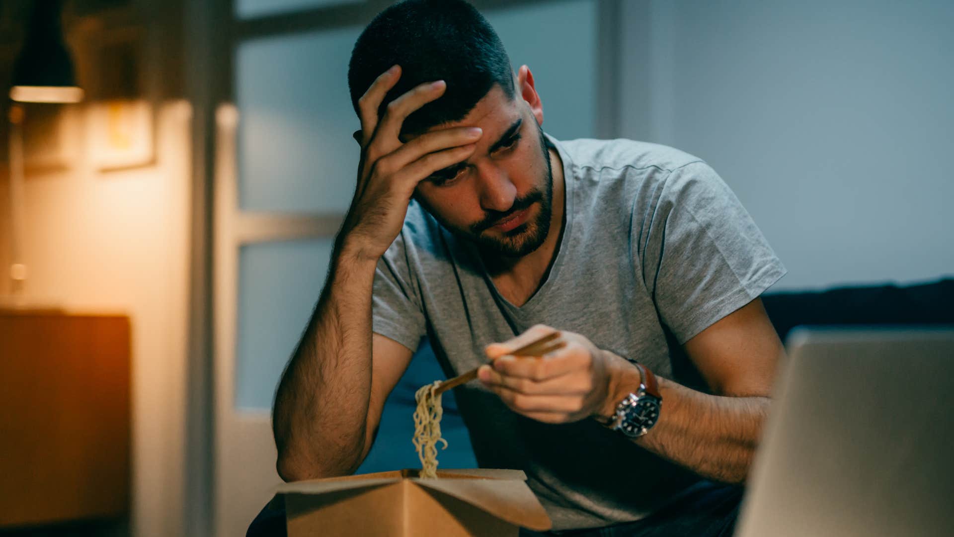Man using food as a coping mechanism at home.