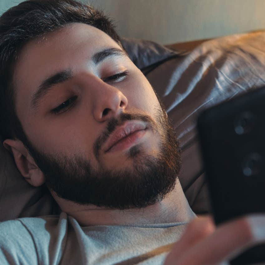undisciplined man overusing ai and chatgpt on his phone in bed