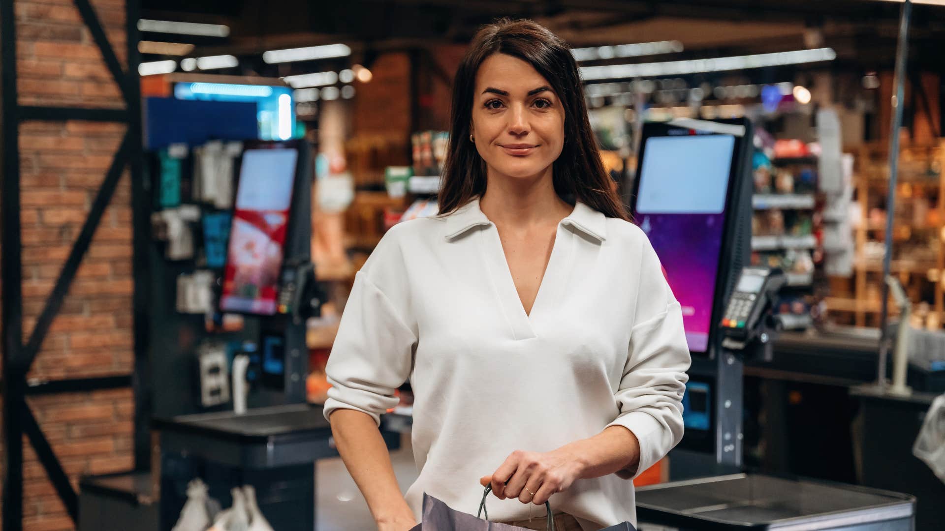woman driven by convenience using the self-checkout at grocery store