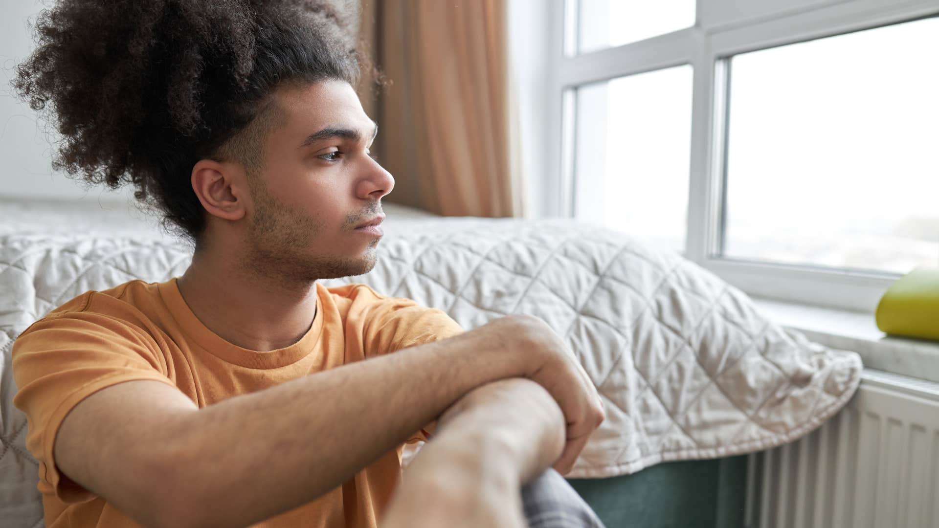 restless man looking out window forlornly