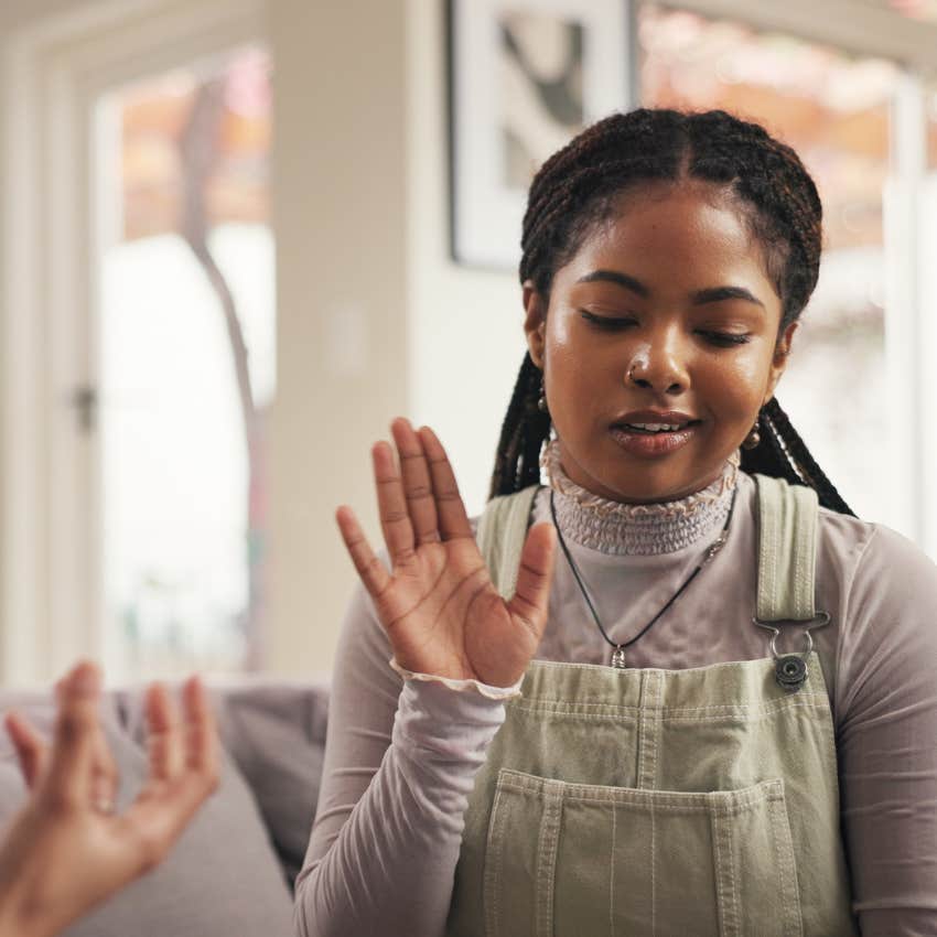 emotionally intelligent woman annoyed putting her hand up in conversation