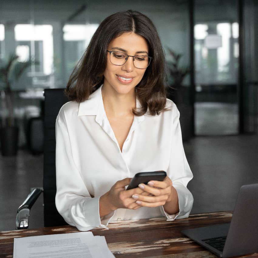 woman texting on smartphone while at work