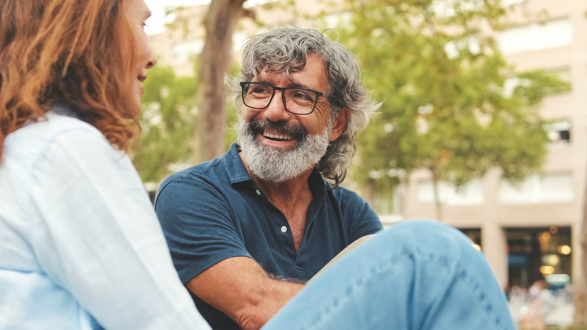 close-up of smiling man talking to woman outside