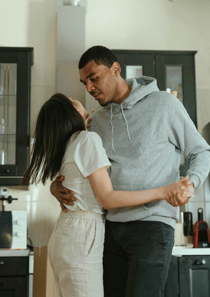 playful couple dancing in their living room